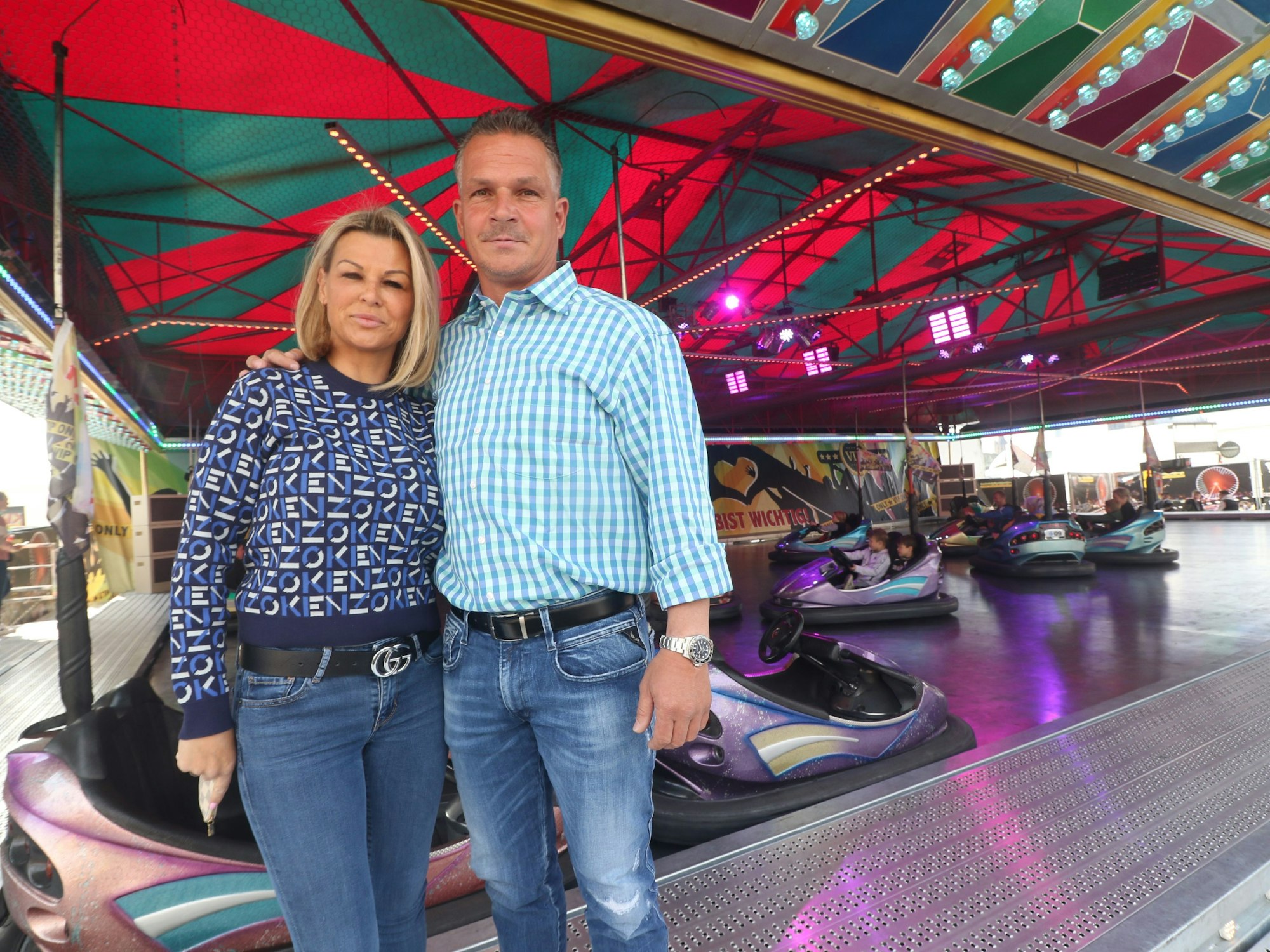 Schausteller stehen an einem Fahrgeschäft auf der Deutzer Kirmes.