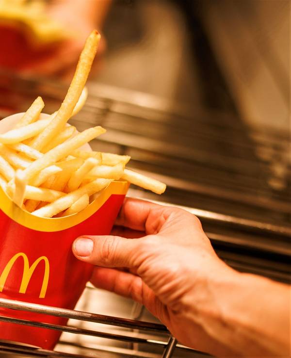 McDonald's und Burger King stehen für günstiges und schnelles Fast-Food-Essen. Doch auch hier mussten Kundinnen und Kunden in den letzten Monaten und Jahren immer mehr draufzahlen. Unser Archivbild vom Dezember 2021 zeigt Tüten mit Pommes frites in einer McDonald's-Filiale.