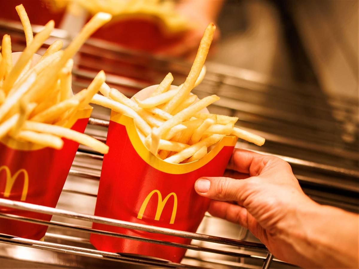 McDonald's und Burger King stehen für günstiges und schnelles Fast-Food-Essen. Doch auch hier mussten Kundinnen und Kunden in den letzten Monaten und Jahren immer mehr draufzahlen. Unser Archivbild vom Dezember 2021 zeigt Tüten mit Pommes frites in einer McDonald's-Filiale.
