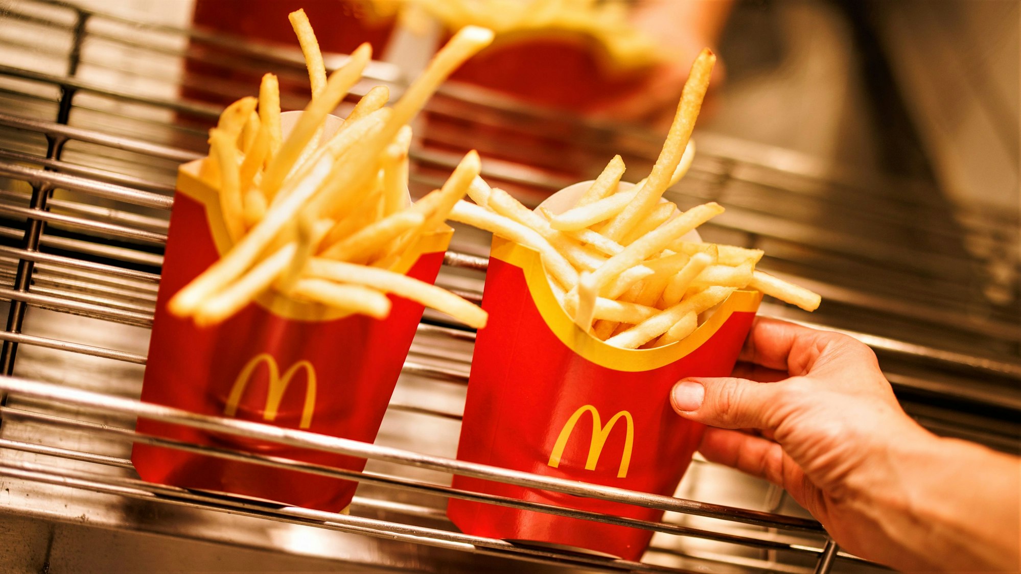 McDonald's und Burger King stehen für günstiges und schnelles Fast-Food-Essen. Doch auch hier mussten Kundinnen und Kunden in den letzten Monaten und Jahren immer mehr draufzahlen. Unser Archivbild vom Dezember 2021 zeigt Tüten mit Pommes frites in einer McDonald's-Filiale.