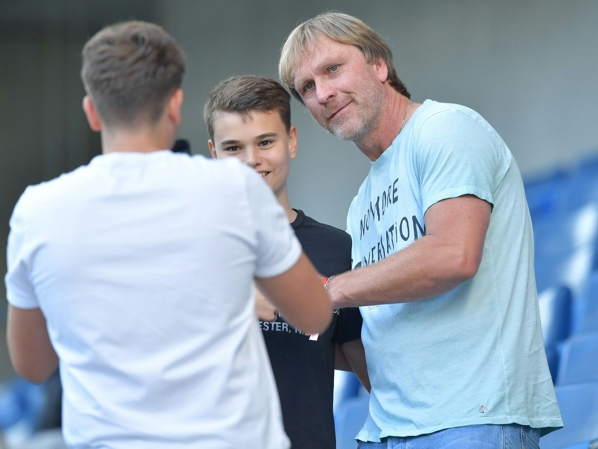 Der ehemalige Fussballer Ansgar Brinkmann (r) lässt sich auf einer Tribüne von Fans fotografieren.