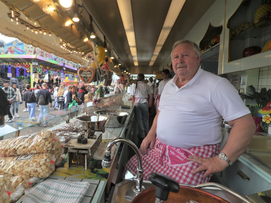 Ein Schausteller sitzt in seiner Bude auf der Deutzer Kirmes.