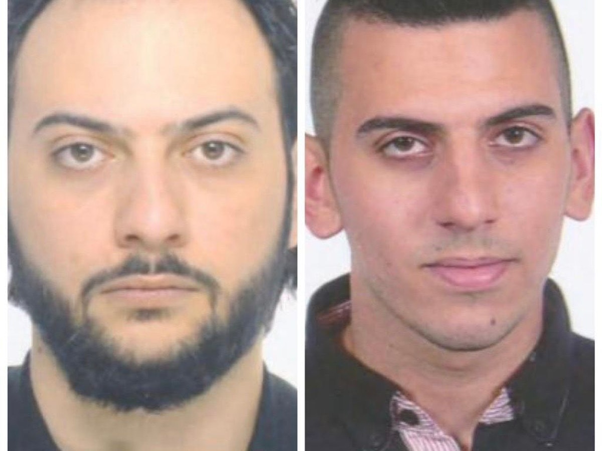 Zwei Männer schauen auf einem Fahndungsfoto in die Kamera.