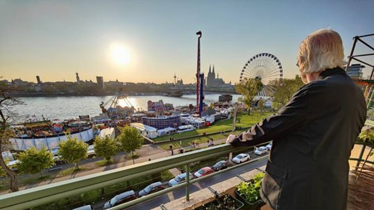 Ein Anwohner der Deutzer Werft steht auf dem Balkon und blickt auf die Osterkirmes.
