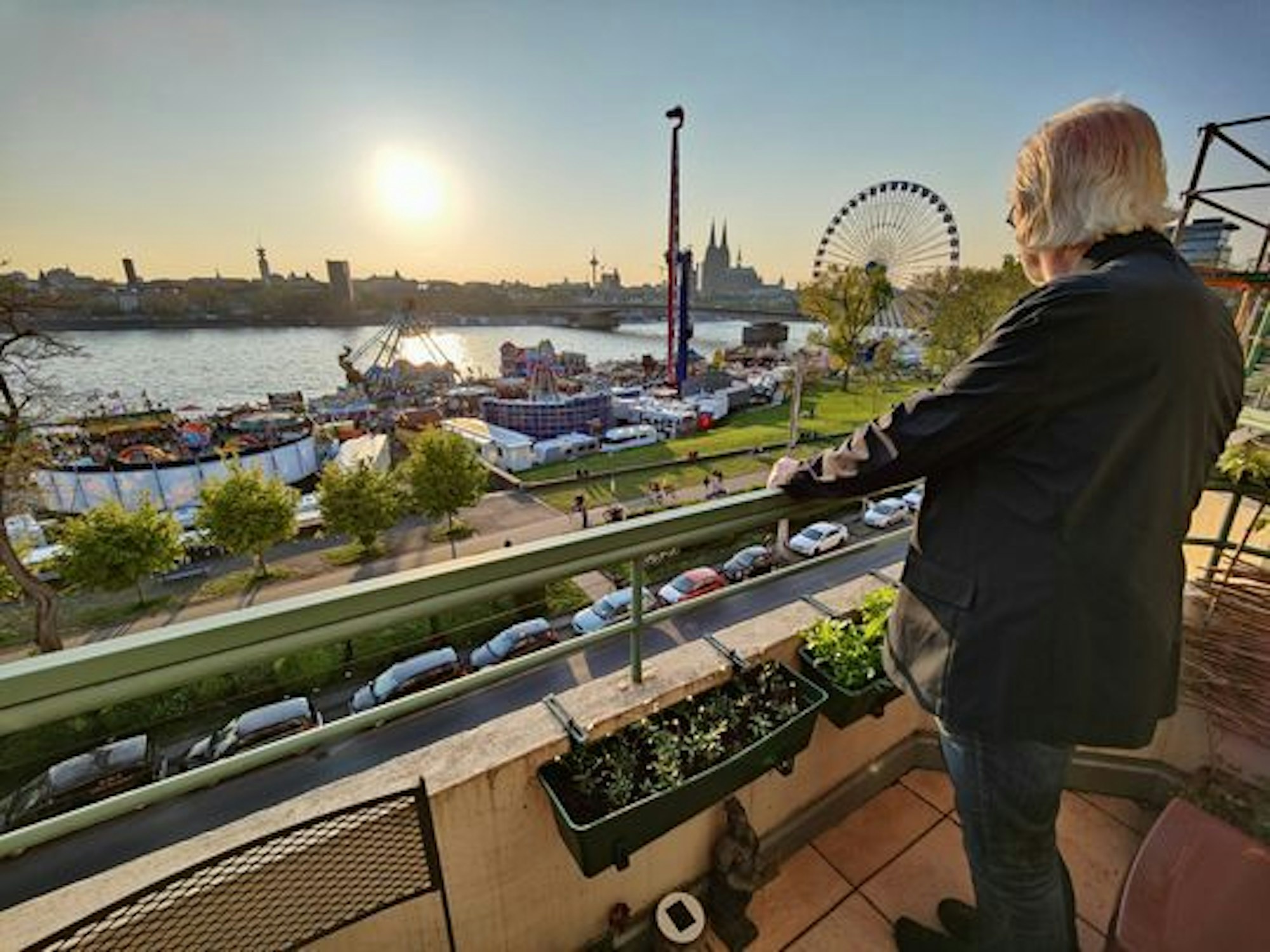 Ein Anwohner der Deutzer Werft steht auf dem Balkon und blickt auf die Osterkirmes.