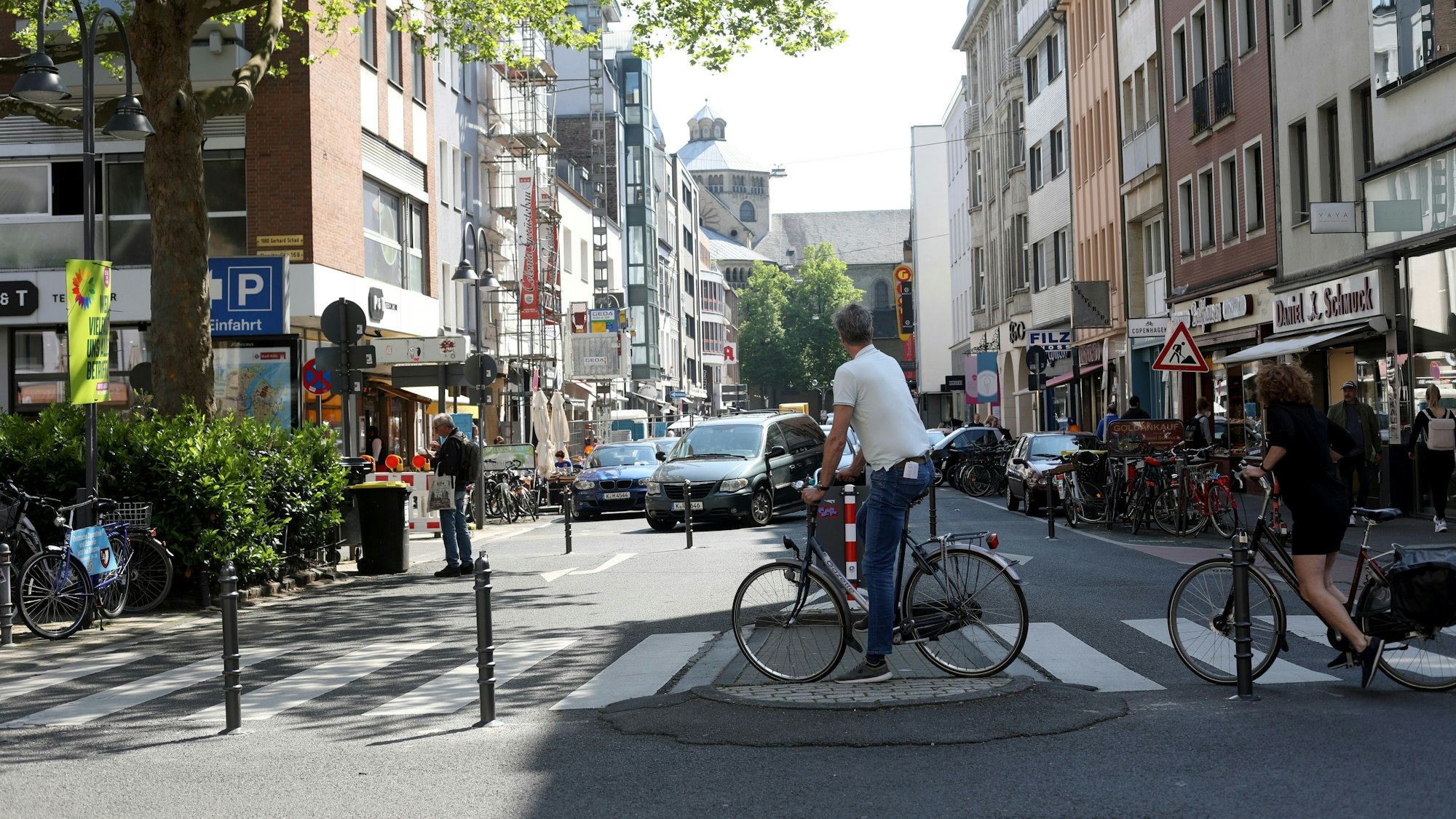 Radfahrende und Autos an der Apostelstraße Ecke Ehrenstraße in Köln.