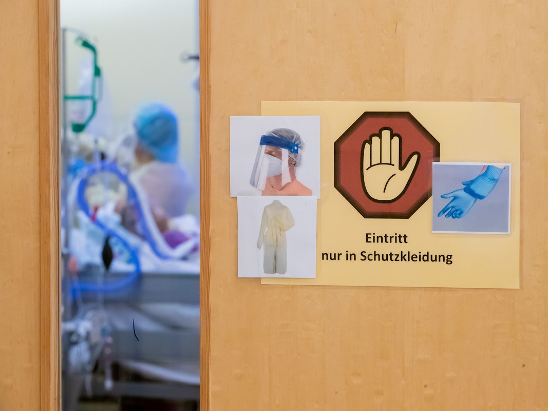 Ein Warnschild zum Tragen von Schutzkleidung hängt auf der Intensivstation des Gemeinschaftskrankenhauses Havelhöhe an der Tür eines Covid-19-Patientenzimmers.