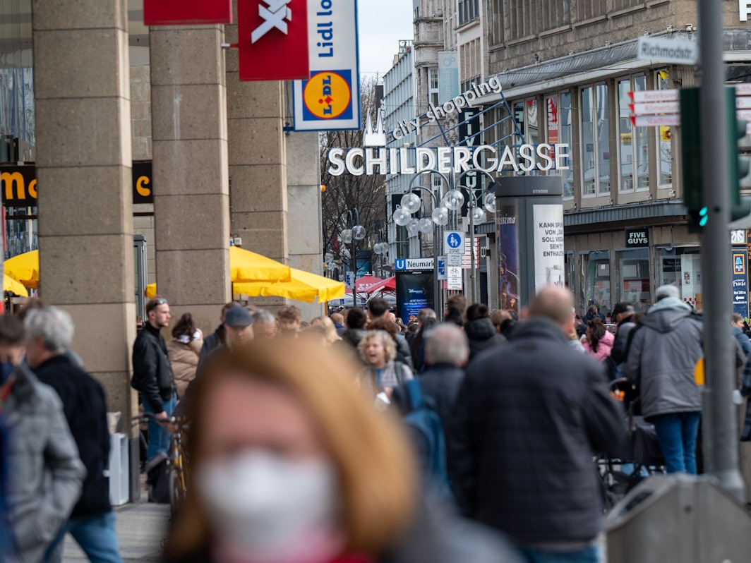 Die Schildergasse ist voller Menschen. Viele genießen das frühlingshafte Wetter im Freien.
