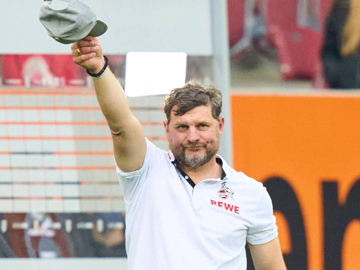 Steffen Baumgart zieht die Mütze vor der FC-Fankurve in Augsburg.
