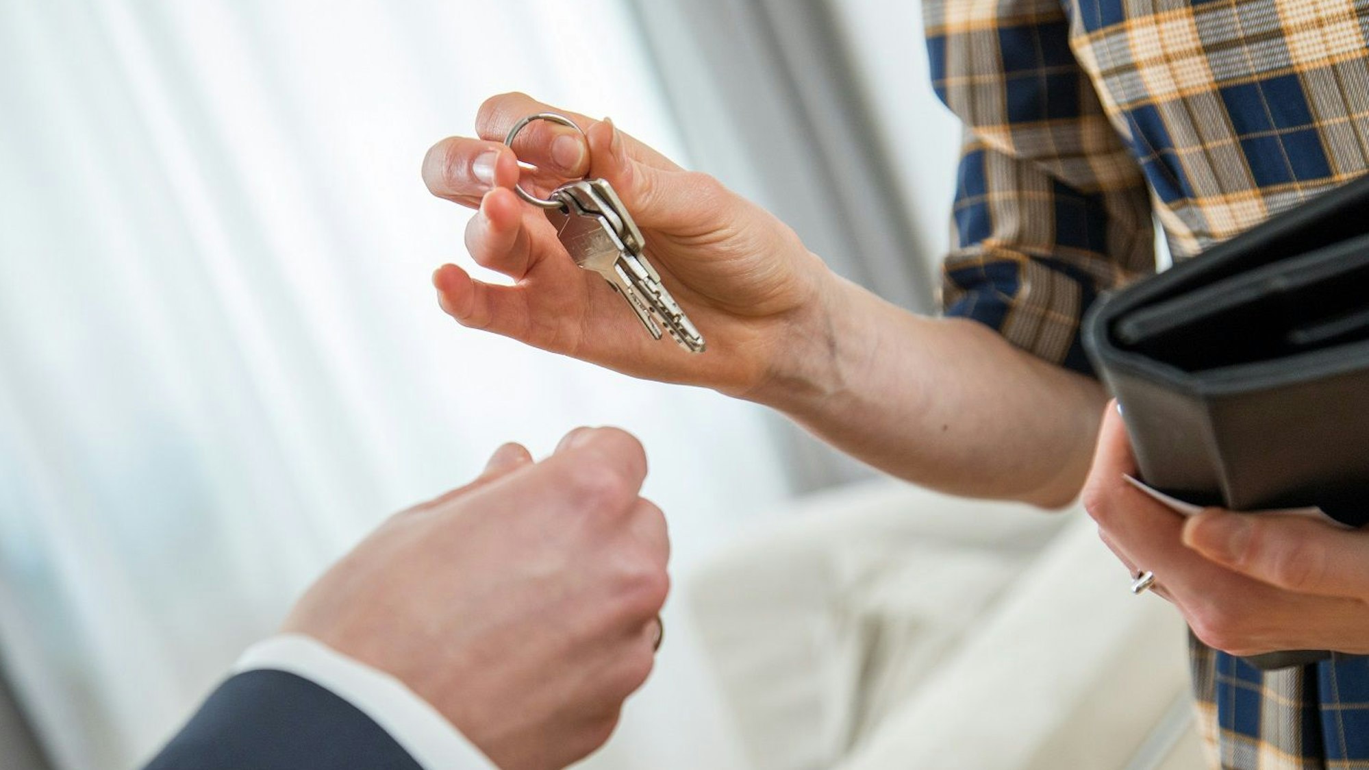 Eine Person überreicht einer anderen Person einen Schlüssel. Das Bild ist vom 6. April 2018.