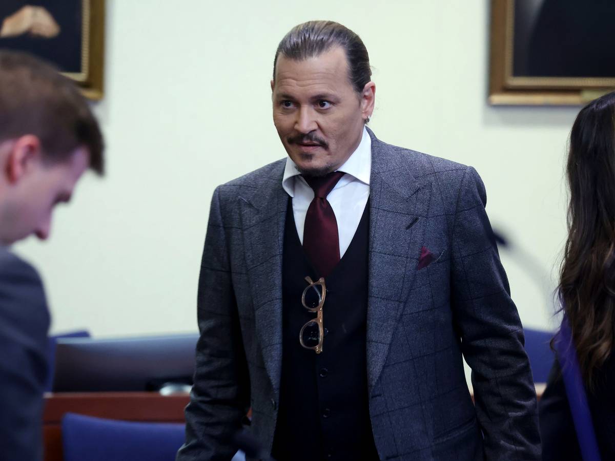 Schauspieler Johnny Depp im Anzug mit strenger Frisur und einem kleinen Lächeln im Gesicht während des Prozesses am 28. April 2022.