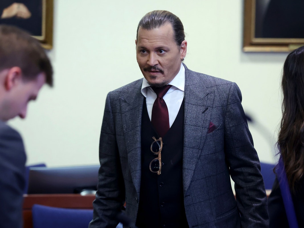 Schauspieler Johnny Depp im Anzug mit strenger Frisur und einem kleinen Lächeln im Gesicht während des Prozesses am 28. April 2022.