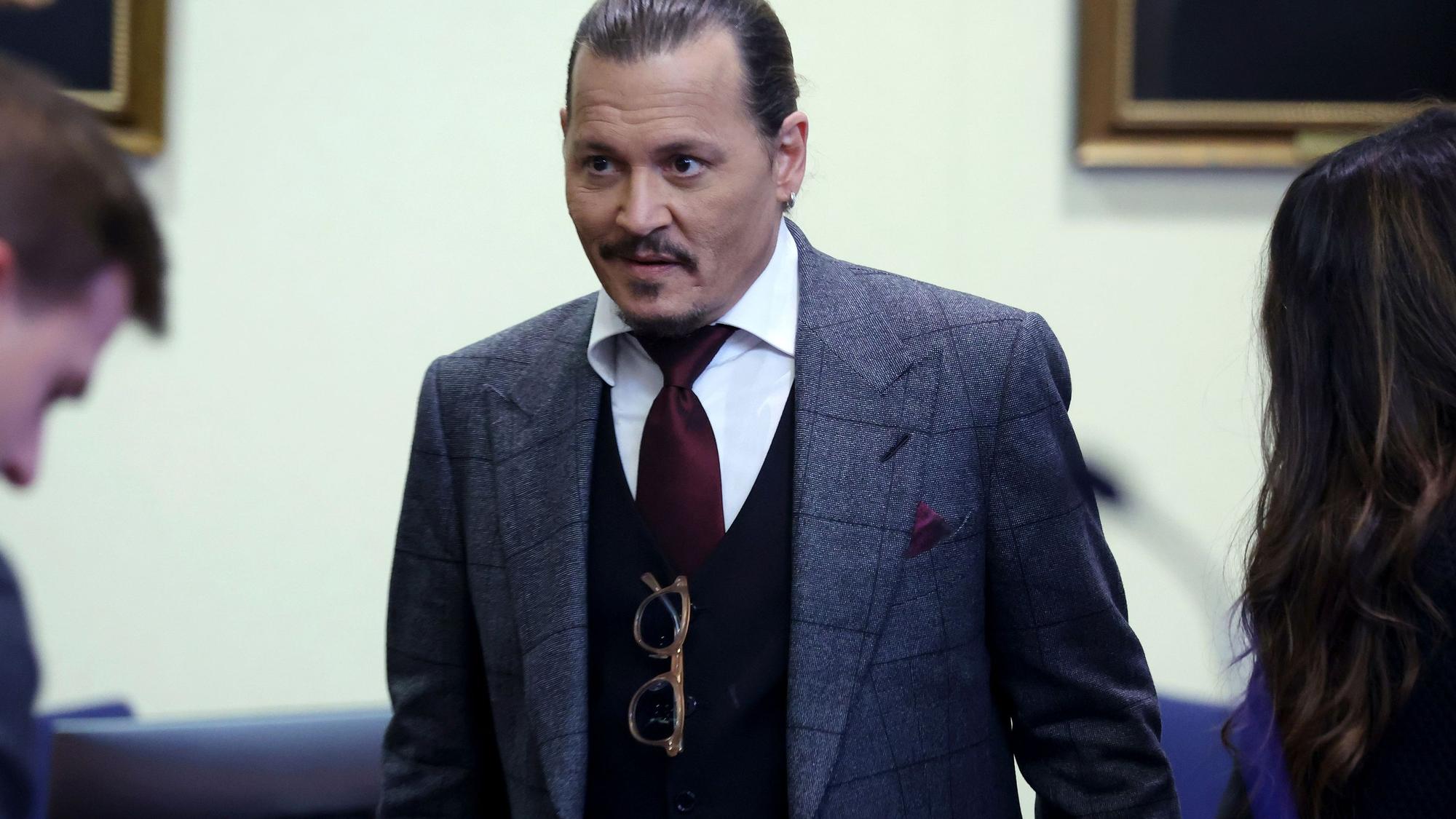 Schauspieler Johnny Depp im Anzug mit strenger Frisur und einem kleinen Lächeln im Gesicht während des Prozesses am 28. April 2022.