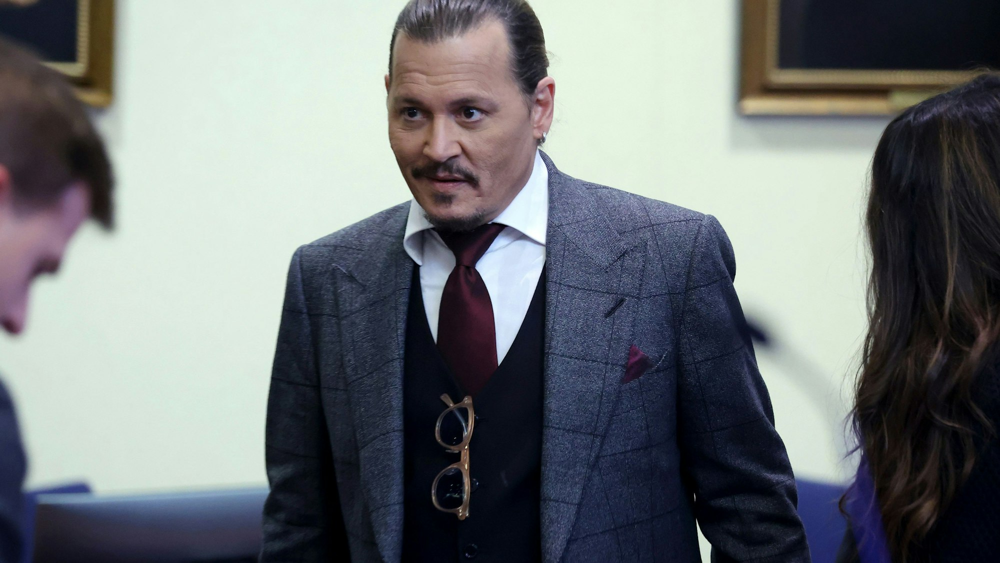 Schauspieler Johnny Depp im Anzug mit strenger Frisur und einem kleinen Lächeln im Gesicht während des Prozesses am 28. April 2022.