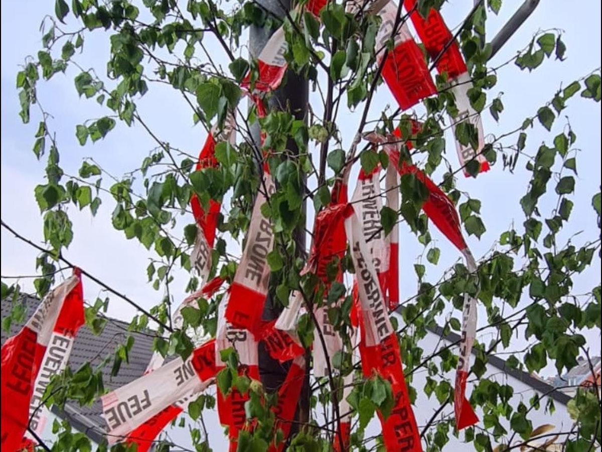 Ein Maibaum ist mit Flatterband der Feuerwehr geschmückt.