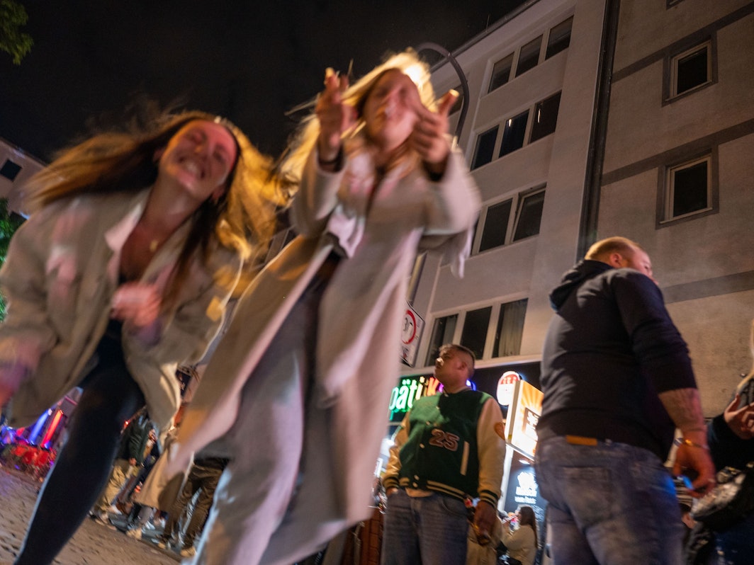 Ein junge Frauen tanzen auf der Straße.