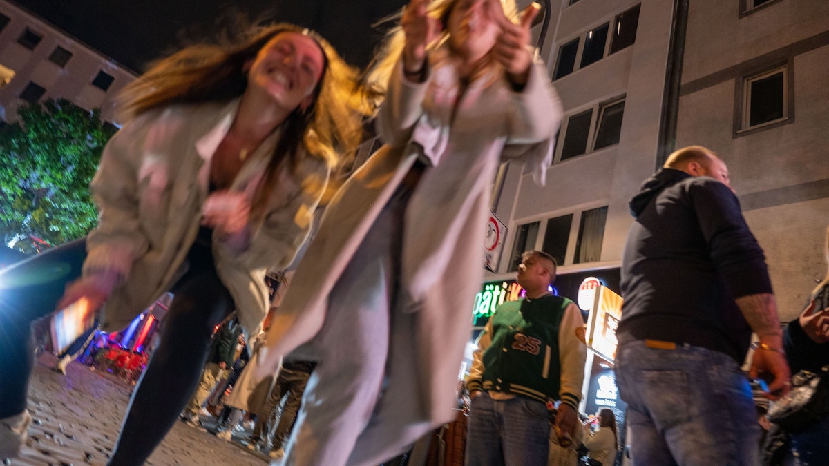 Ein junge Frauen tanzen auf der Straße.