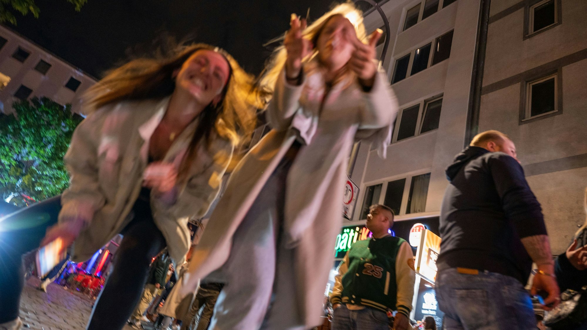 Ein junge Frauen tanzen auf der Straße.