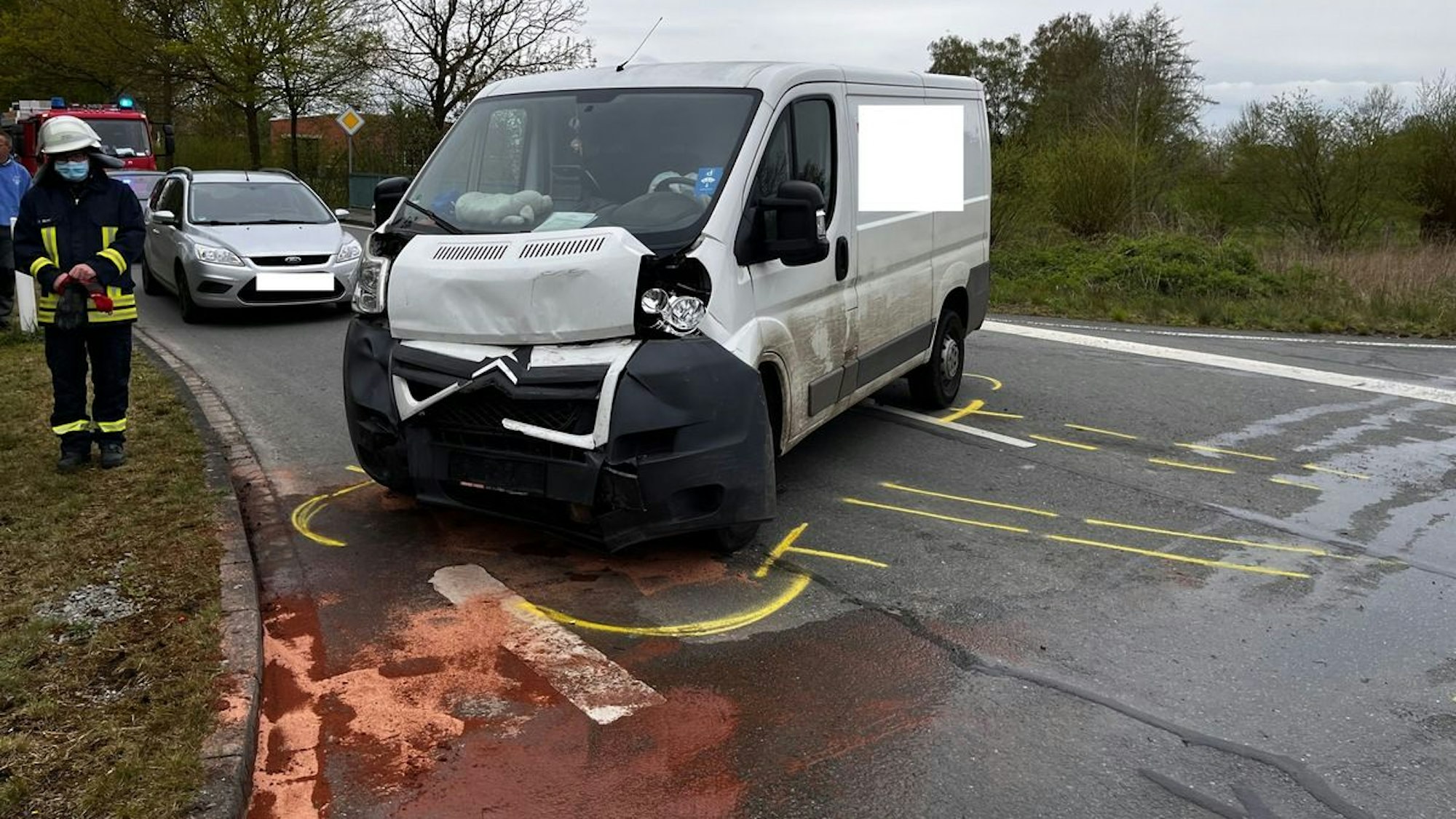 Ein Kleintransporter steht stark beschädigt auf einer Straße.