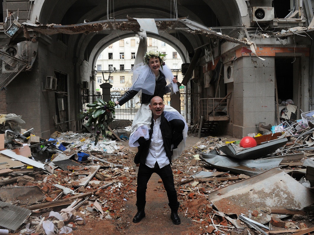 Anastasia (oben) sitzt auf Antons Schultern als sie zu ihrer Hochzeitsfeier in einem Hof eines, durch Beschuss des russischen Militärs, zerstörten Wohnhaus stehen.