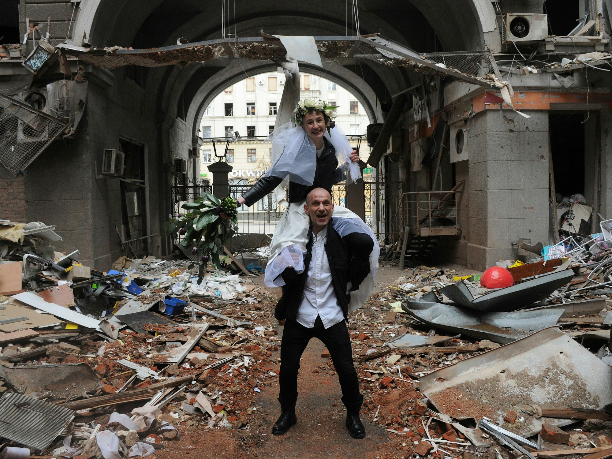Anastasia (oben) sitzt auf Antons Schultern als sie zu ihrer Hochzeitsfeier in einem Hof eines, durch Beschuss des russischen Militärs, zerstörten Wohnhaus stehen.