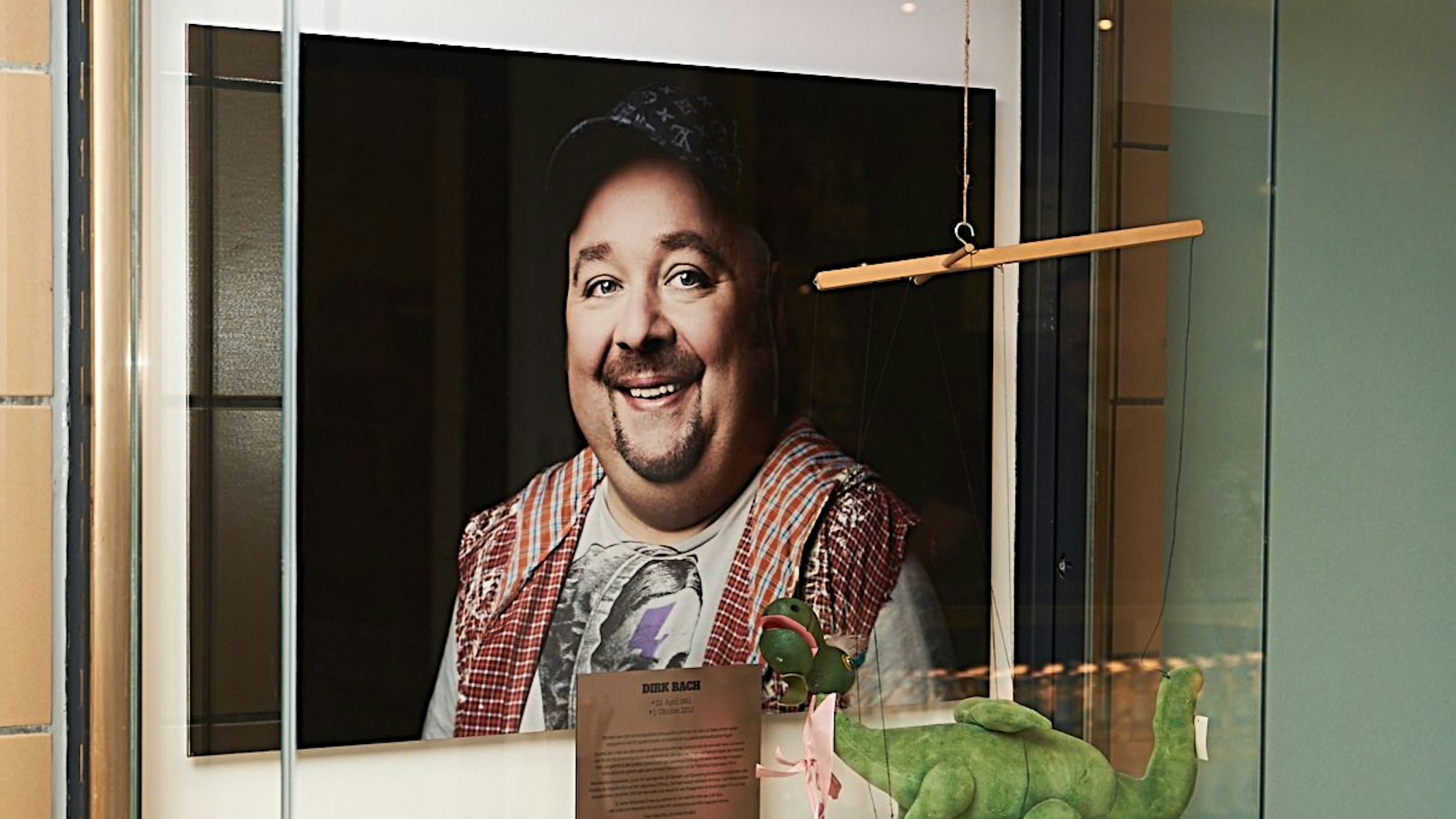 Die Vitrine im neuen Café Bach, in der ein Foto und verschiedene Erinnerungsstücke an den verstorbenen Dirk Bach zu sehen sind.