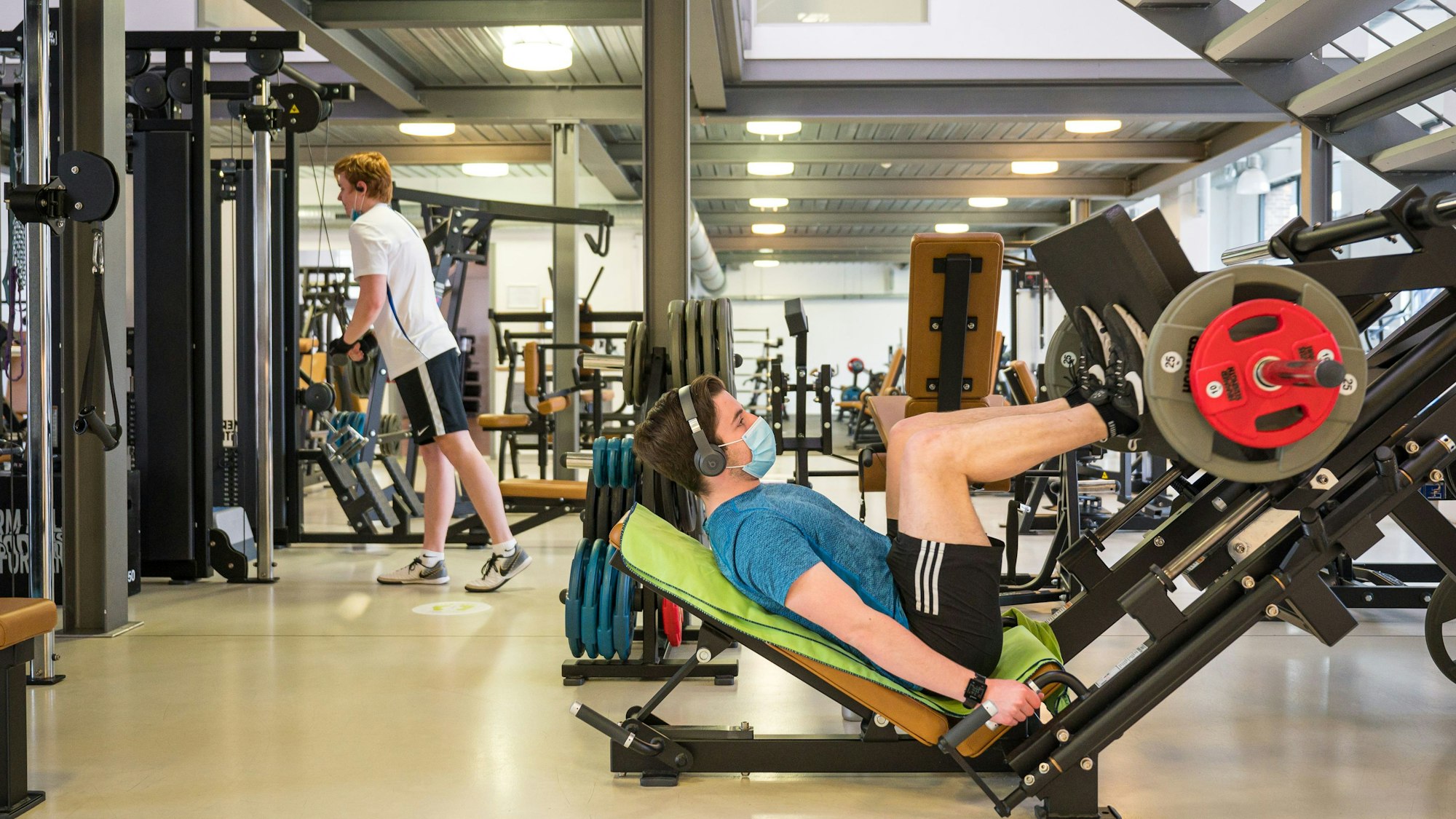In einem Fitness-Studio in Saarbrücken trainieren am 6. April 2021 wieder Menschen an Trainigsgeräten.