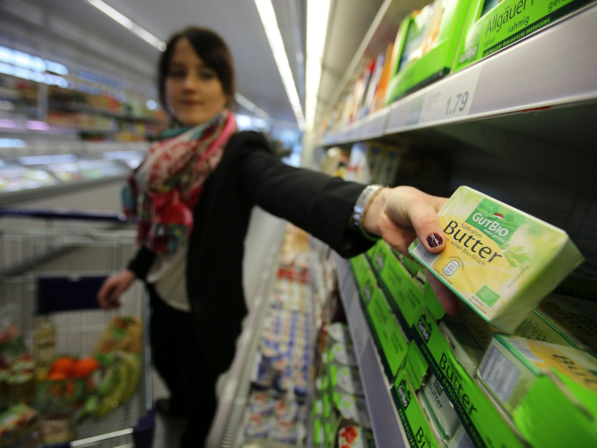 Eine Frau nimmt am 13.03.2015 in Velbert (Nordrhein-Westfalen) in einem Supermarkt von Aldi (Nord) Bio Butter aus dem Regal.