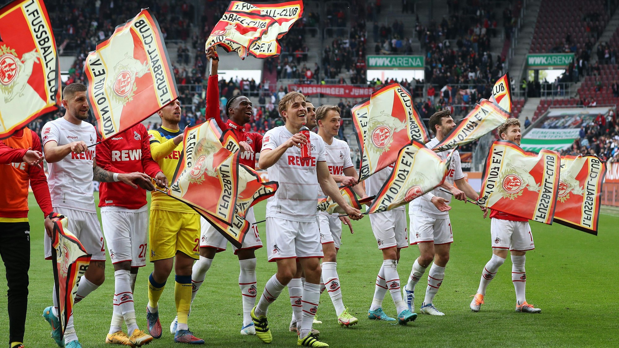 Nach dem Sieg in Augsburg feiern die FC-Profis mit Fähnchen in der Fankurve.