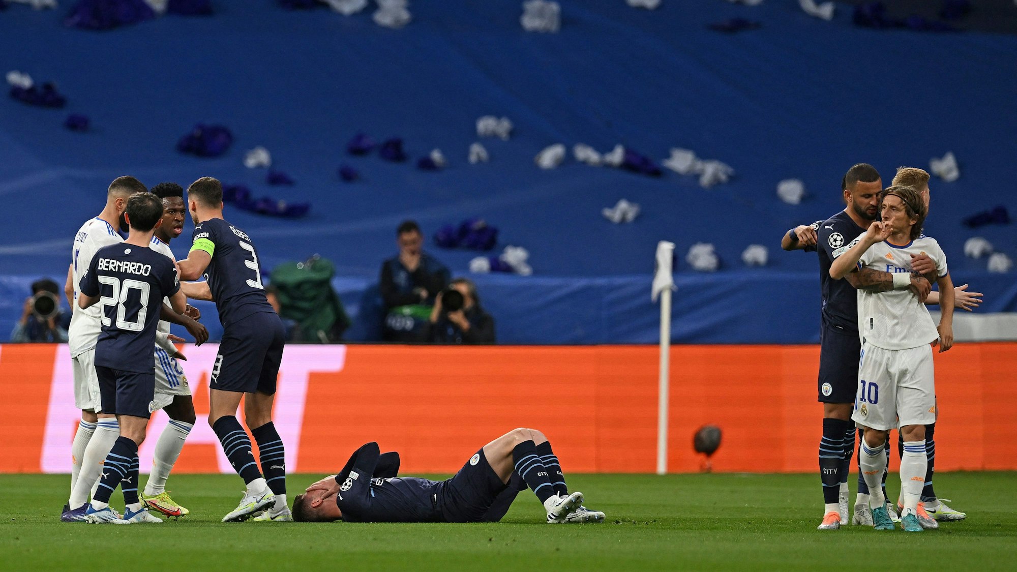 Rangelei im Spiel zwischen Real Madrid und Manchester City. Im Hintergrund ist eine blaue Plane auf der Tribüne zu sehen