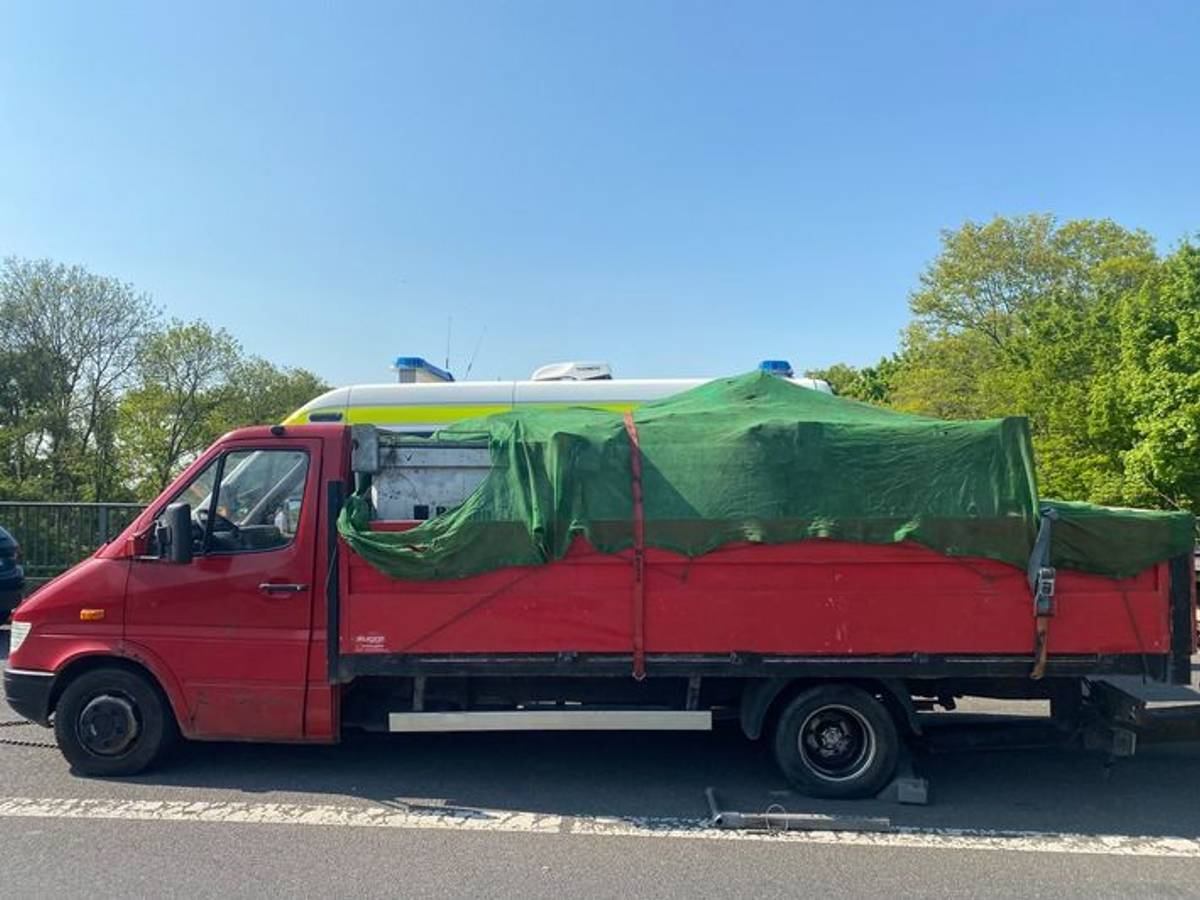 Ein roter Lkw steht an der Straße. Das Fahrzeug wurde von der Autobahnpolizei Köln aus dem Verkehr gezogen – es wies erhebliche Mängel auf.