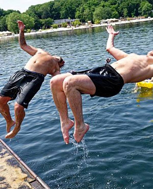 Zwei junge Männer springen am 18. Juni 2021 in den Fühlinger See.