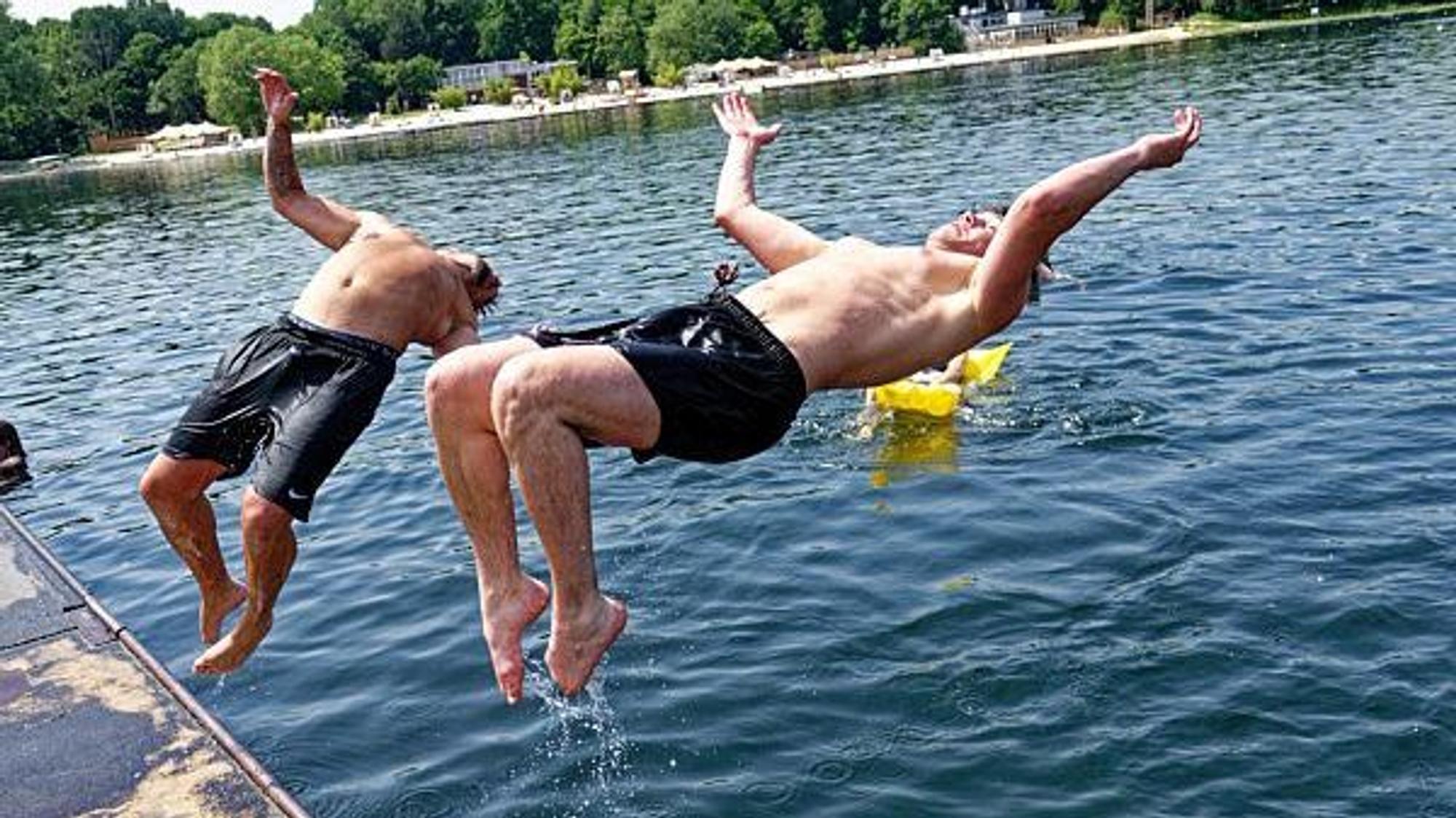 Zwei junge Männer springen am 18. Juni 2021 in den Fühlinger See.
