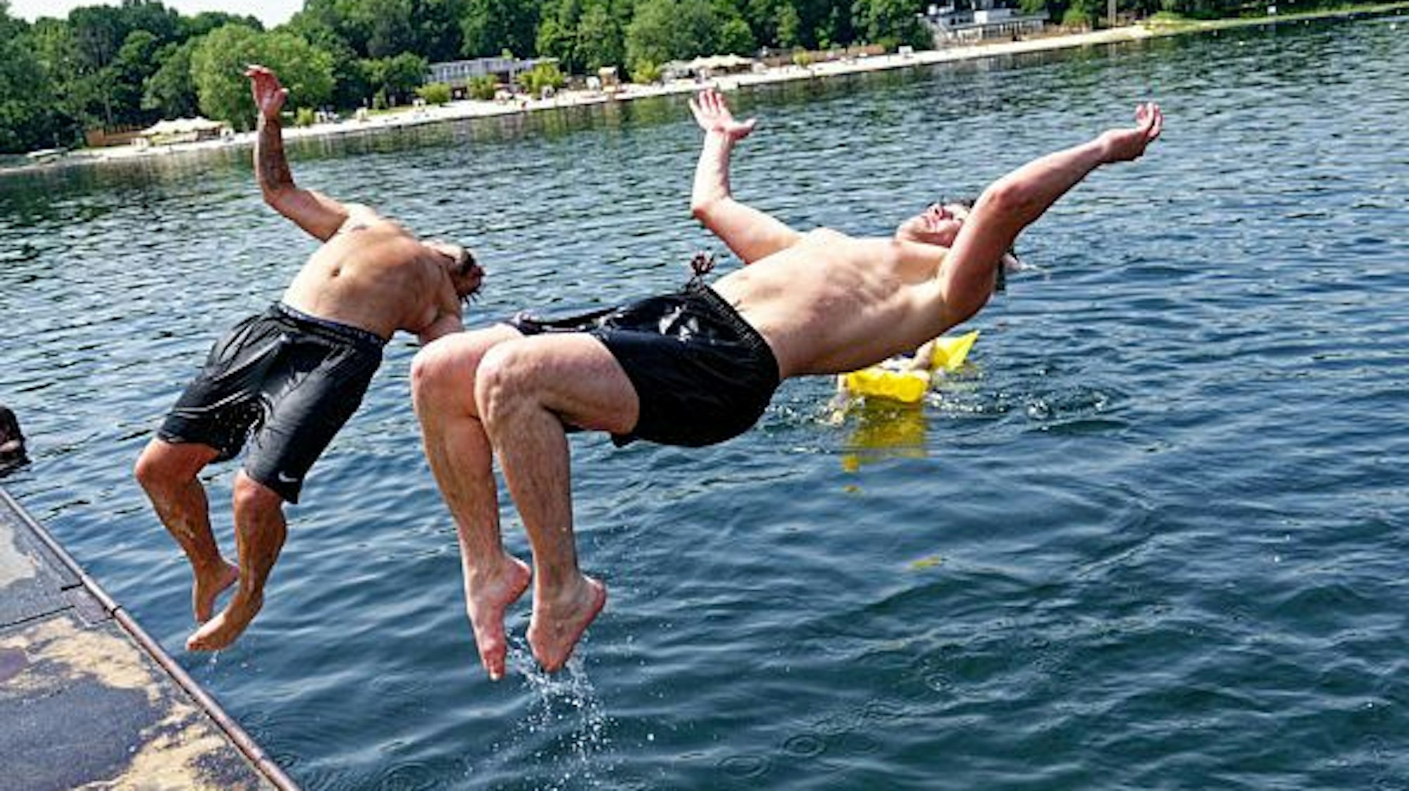 Zwei junge Männer springen am 18. Juni 2021 in den Fühlinger See.