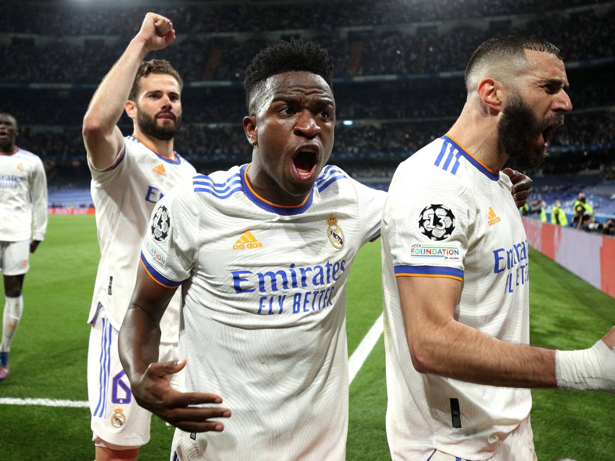 Karim Benzema (r.) jubelt mit Vinicius Junior (Mitte) und Nacho Fernandes über seinen verwandelten Elfmeter zum 3:1.