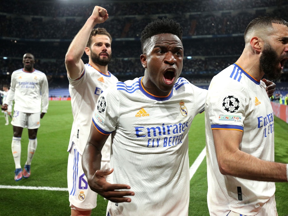Karim Benzema (r.) jubelt mit Vinicius Junior (Mitte) und Nacho Fernandes über seinen verwandelten Elfmeter zum 3:1.