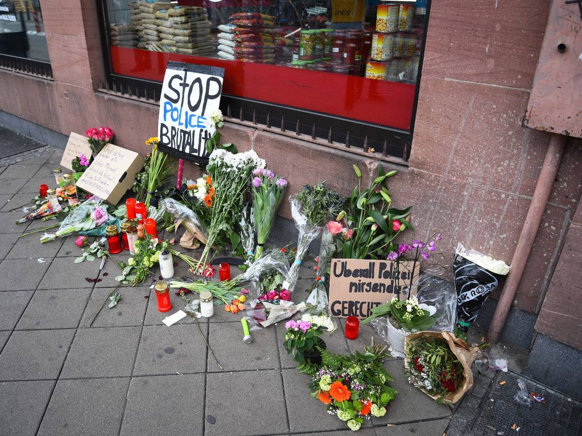 Blumen, Kerzen und Schilder liegen und stehen an dem Ort, an dem am Montag (2. Mai 2022) ein Mann nach einer Polizeikontrolle gestorben ist.