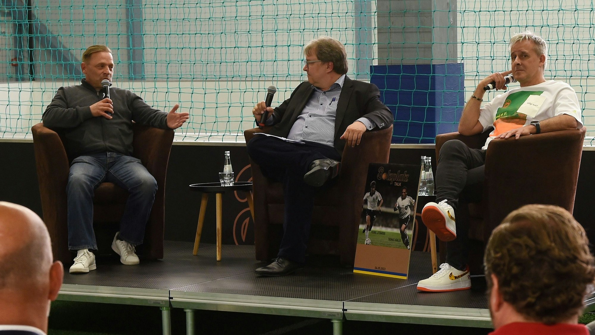 04.05.2022, Hürth: FC-Talk im Hürther Bolzplatz mit den Fußball-Weltmeistern Pierre Littbarski und Thomas Häßler.
v.li. Thomas Häßler, Achim Hannott und Pierre Littbarski
Foto: Csaba Peter Rakoczy