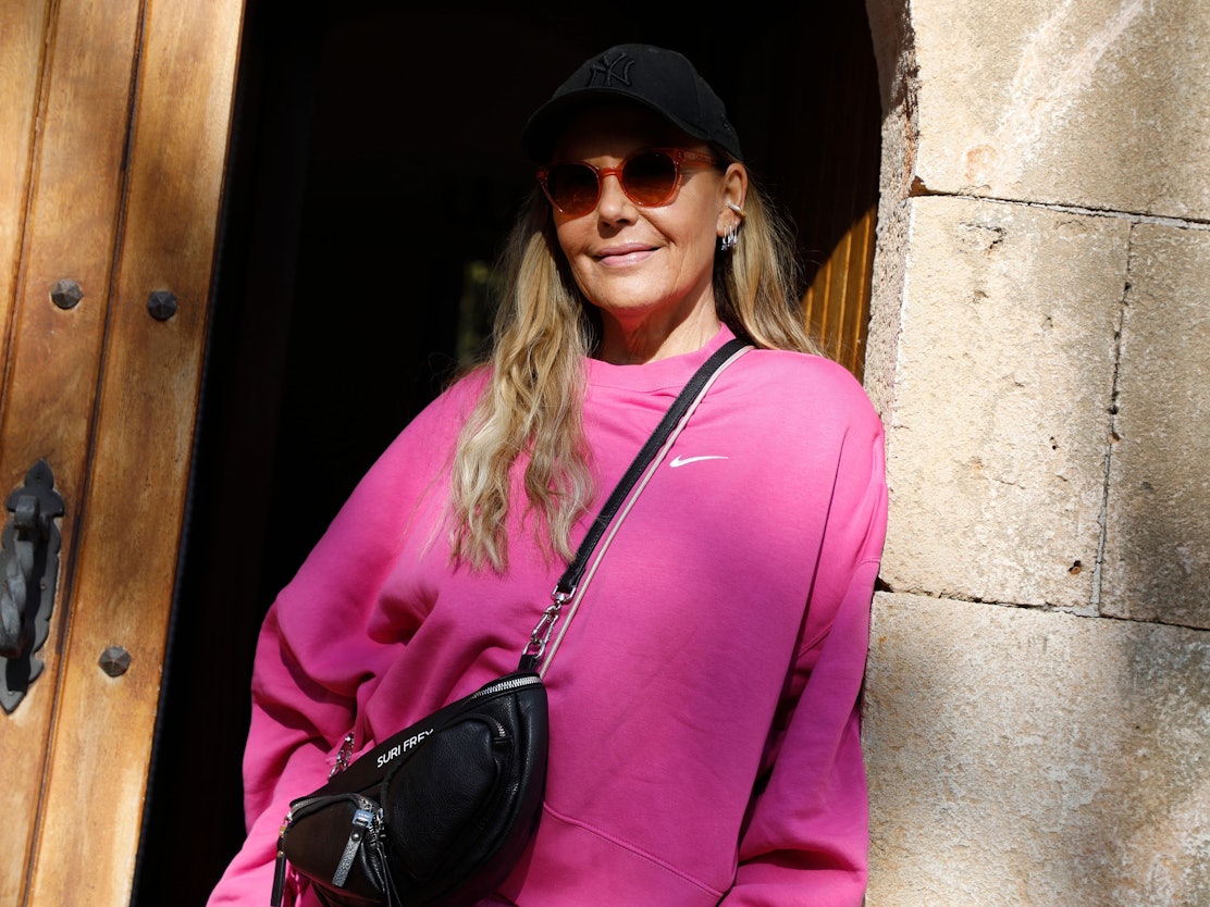 Natascha Ochsenknecht steht am 25. November 2021 in der Tür eines Hauses auf Mallorca in einem knallpinken Oberteil und trägt eine Sonnenbrille und eine schwarze Cap.