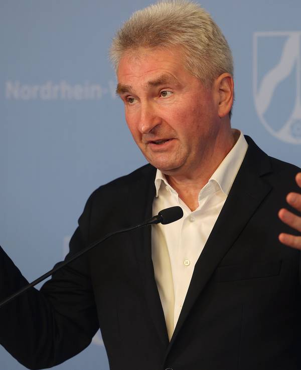 Andreas Pinkwart (FDP) mit erhobenen Händen im Anzug bei einer Rede am 21. Februar 2022.