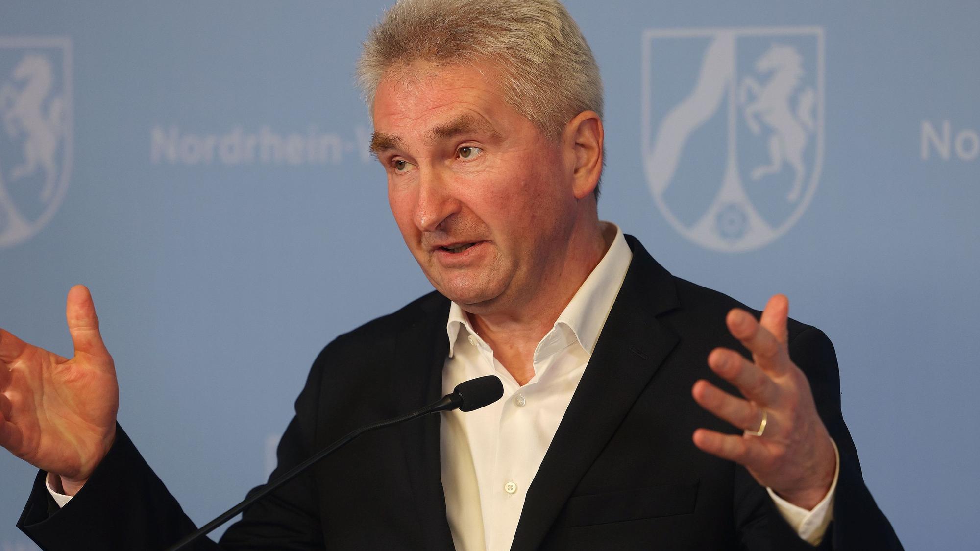 Andreas Pinkwart (FDP) mit erhobenen Händen im Anzug bei einer Rede am 21. Februar 2022.