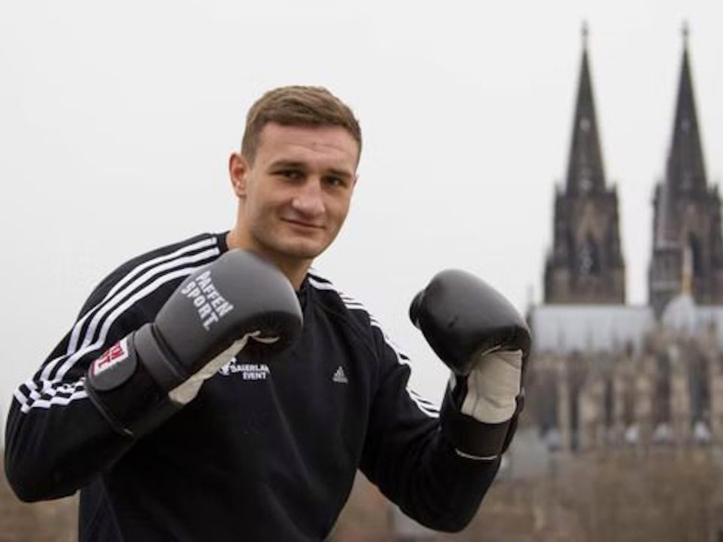 Der Boxer Denis Radovan posiert vor dem Kölner Dom.