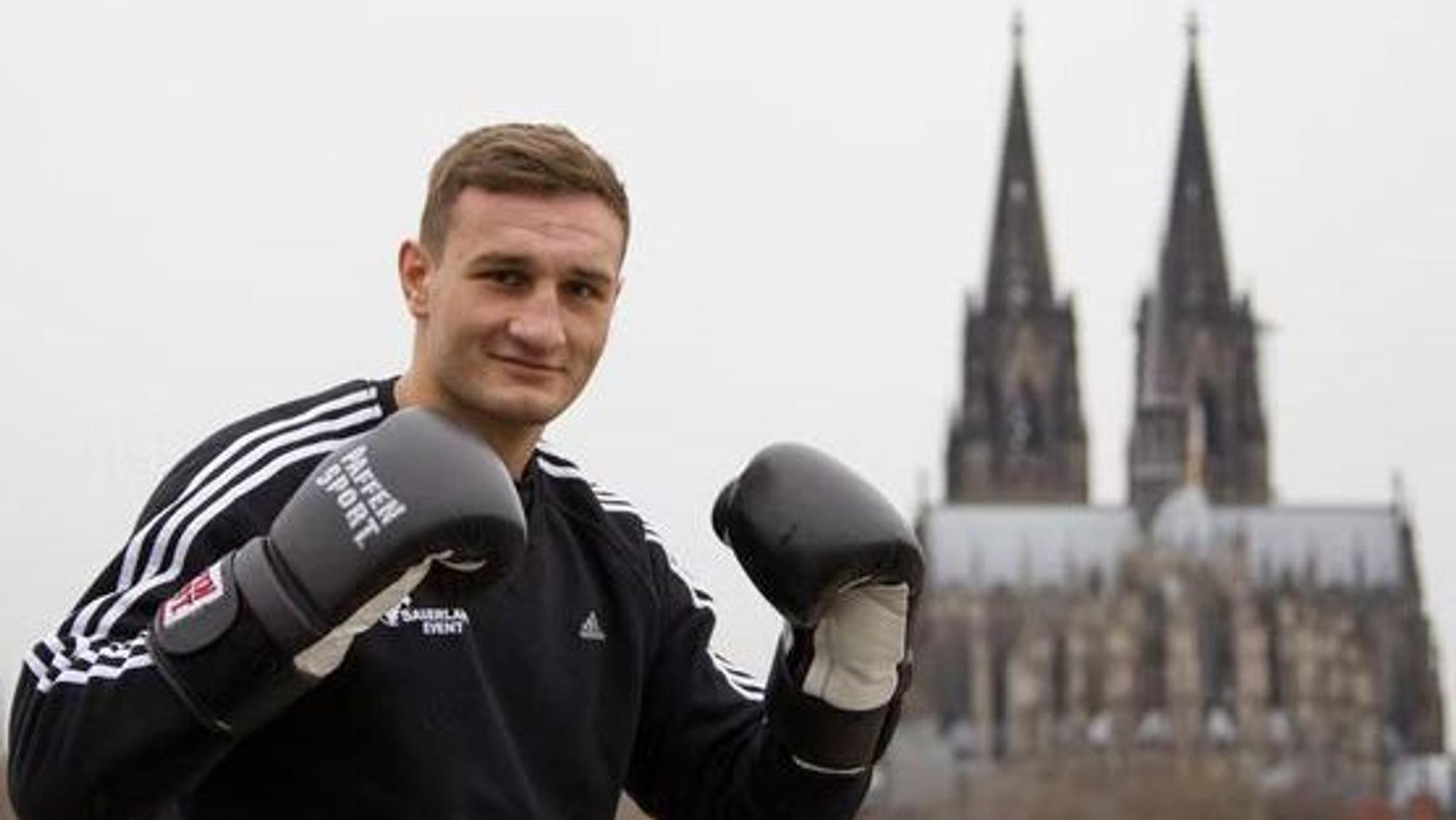 Der Boxer Denis Radovan posiert vor dem Kölner Dom.