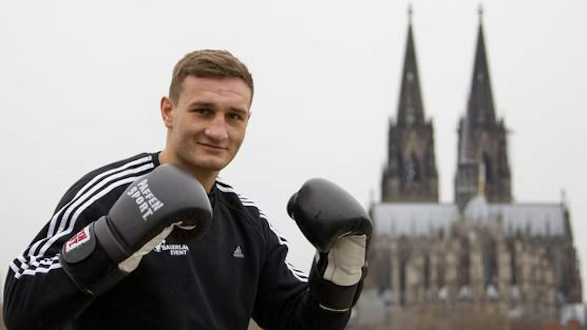 Der Boxer Denis Radovan posiert vor dem Kölner Dom.