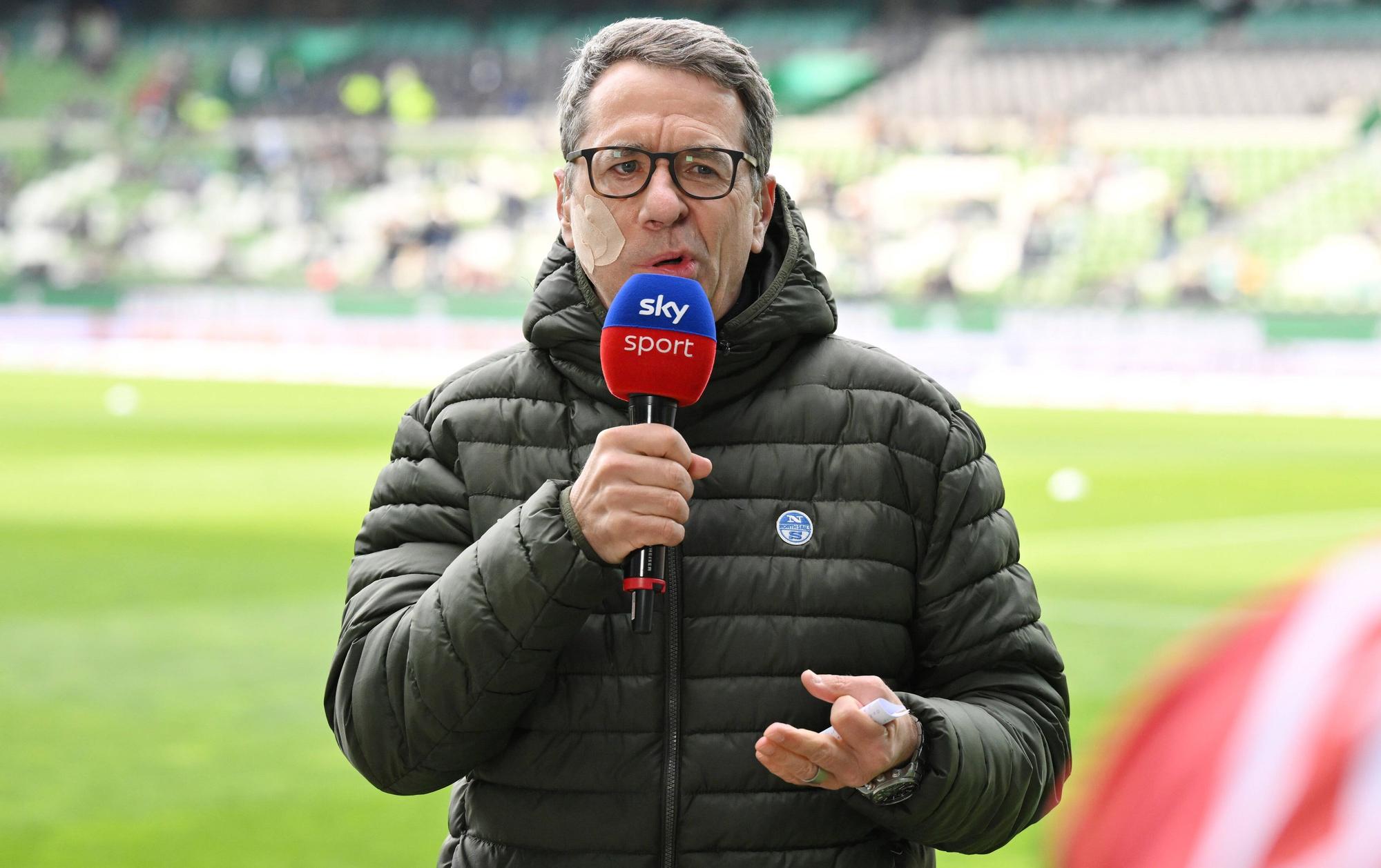 Marcus Lindemann spricht bei der Sky-Berichterstattung zur 2. Bundesliga. Er trägt wegen einer halbseitigen Gesichtslähmung ein großes Pflaster im Gesicht.