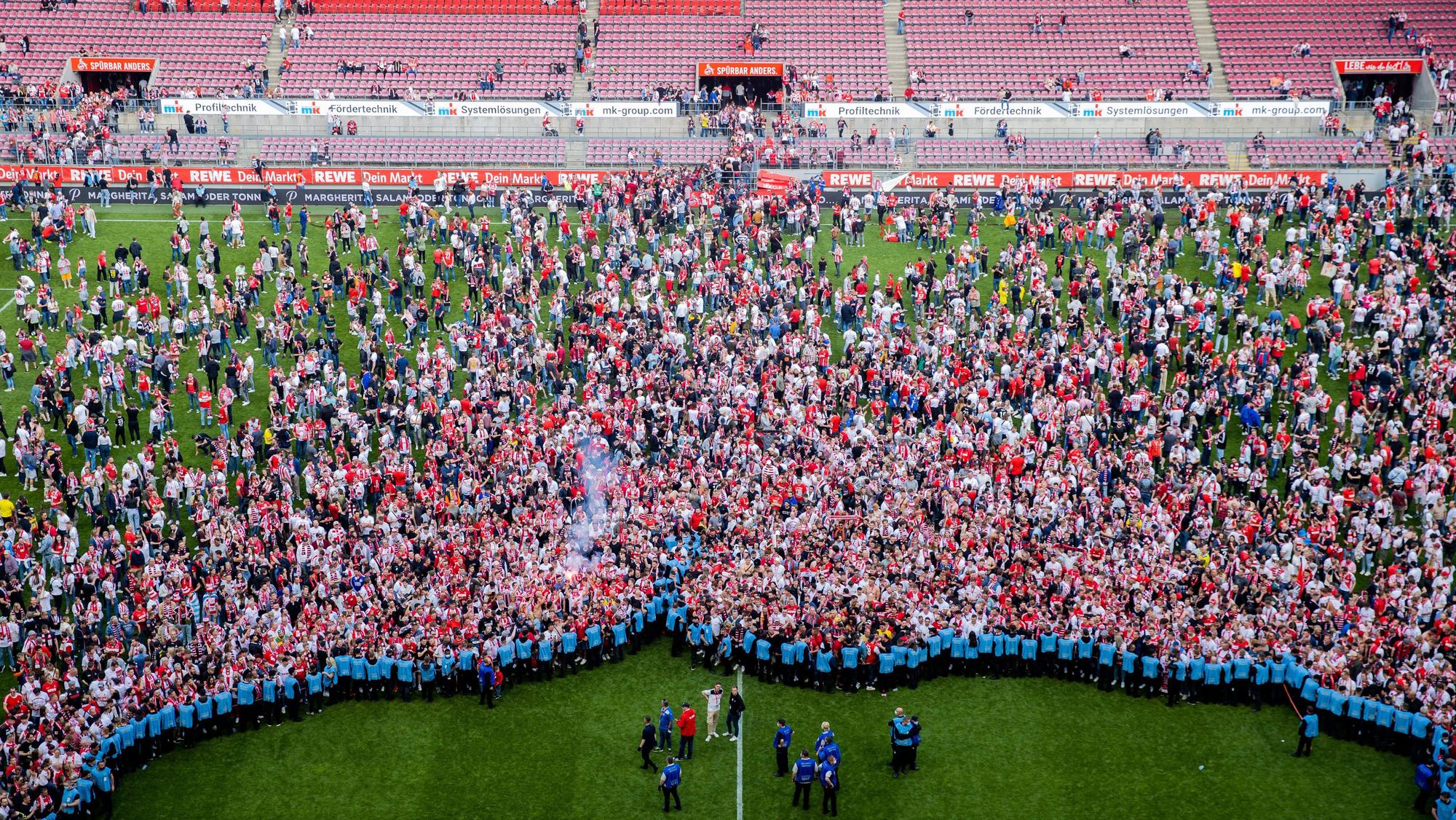 Die Fans des 1. FC Köln stürmen nach dem 0:1 gegen den VfL Wolfsburg den Platz.