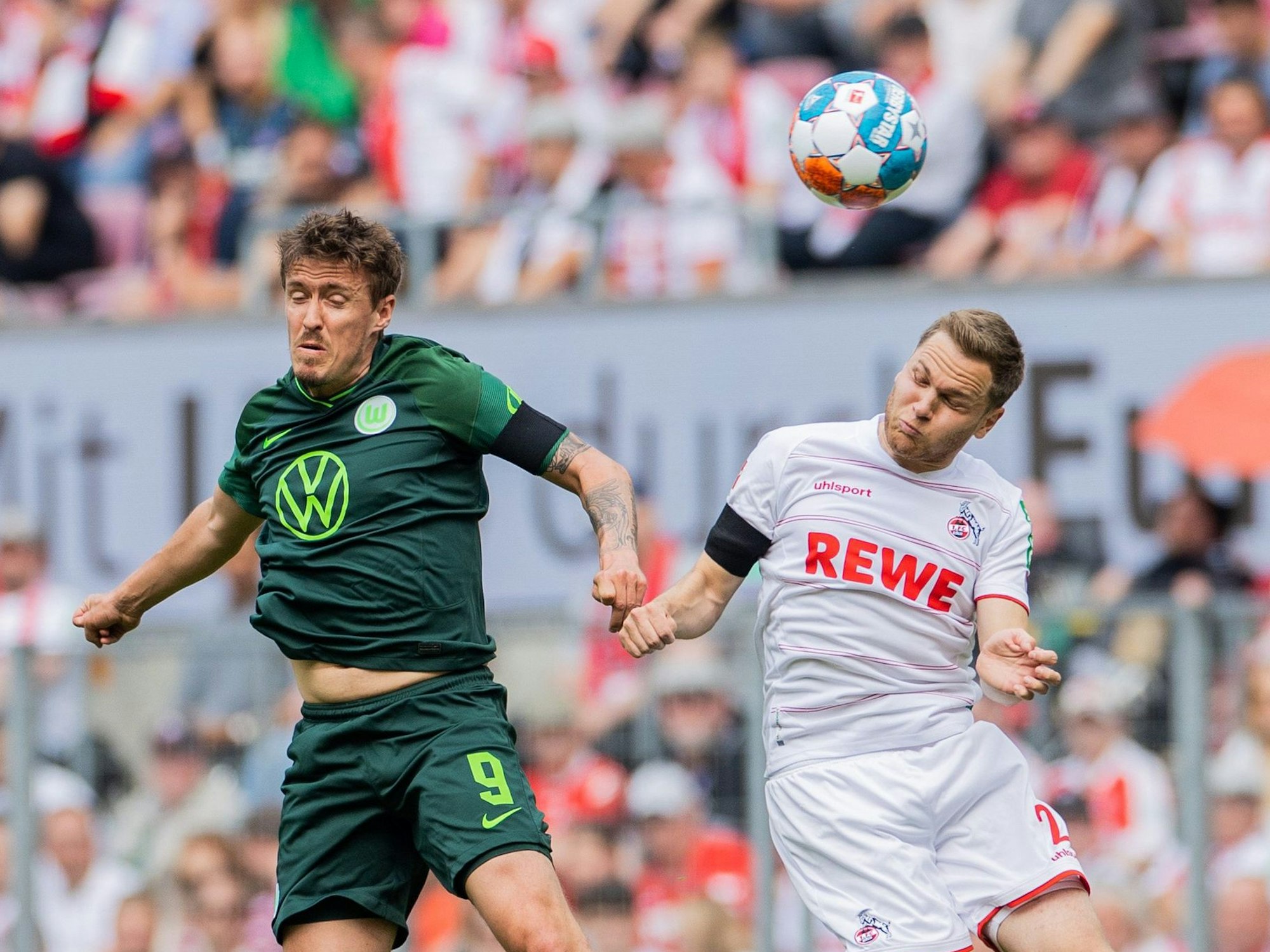 Kölns Benno Schmitz (r) und Wolfsburgs Max Kruse versuchen an den Ball zu kommen.