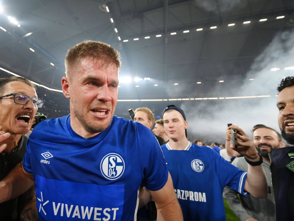 Die Schalker Fans stürmen nach dem Abpfiff den Platz und feiern Simon Terodde.