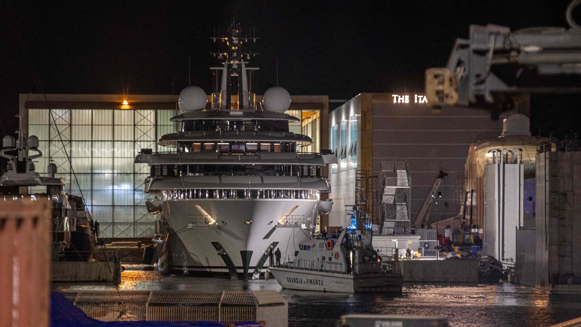 Ein Boot der italienischen Finanzpolizei ist vor der mehrere Millionen Dollar teuren Megayacht Scheherazade zu sehen, die am 6. Mai 2022 im toskanischen Hafen von Marina di Carrara, Toskana, angedockt ist, nachdem ihr Becken wieder geflutet wurde.