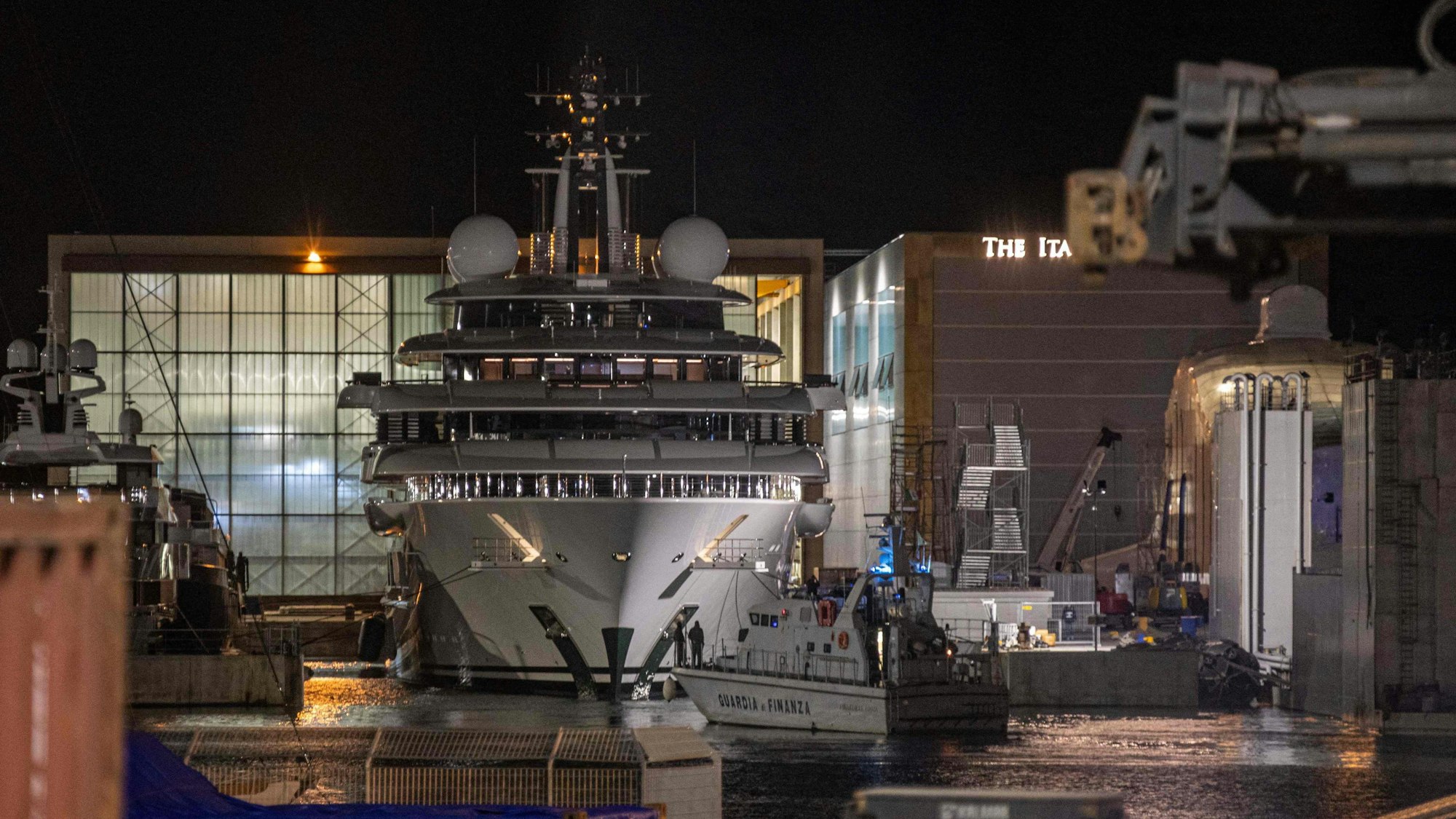 Ein Boot der italienischen Finanzpolizei ist vor der mehrere Millionen Dollar teuren Megayacht Scheherazade zu sehen, die am 6. Mai 2022 im toskanischen Hafen von Marina di Carrara, Toskana, angedockt ist, nachdem ihr Becken wieder geflutet wurde.